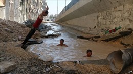 Trẻ em Syria phải tắm trong hố bom