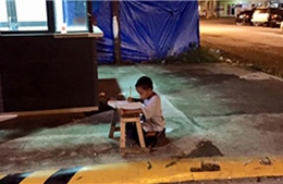 Xúc động cậu bé vô gia cư học bài dưới ánh đèn hắt từ nhà hàng