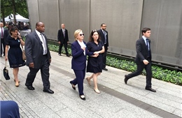 Người phụ nữ bí ẩn mặc đầm xanh theo sát bà Clinton là ai?