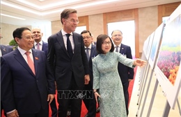 Thủ tướng Phạm Minh Chính và Thủ tướng Hà Lan Mark Rutte tham quan trưng bày ảnh của TTXVN