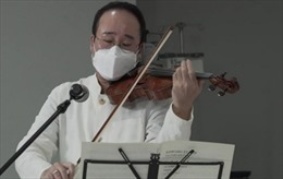 Nghệ sĩ đeo khẩu trang, chơi violin an ủi bệnh nhân COVID-19