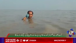 Phóng viên Pakistan đưa tin trong dòng nước lũ ngập đến cằm