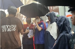 Phụ huynh TP Hồ Chí Minh đợi con tan thi dưới cơn mưa tầm tã 