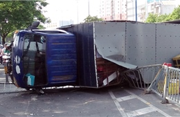 Xe tải san phẳng dải phân cách, lật ngang trên đại lộ Võ Văn Kiệt