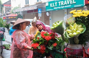 Người dân Hà Nội đội mưa đi mua sắm trong Tết Đoan Ngọ 