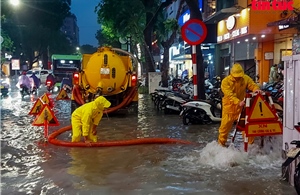Người dân Hà Nội bì bõm lội nước trong trận mưa lớn