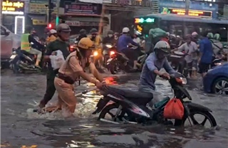 TP Hồ Chí Minh: Ấm lòng hình ảnh CSGT hỗ trợ người dân qua điểm ngập