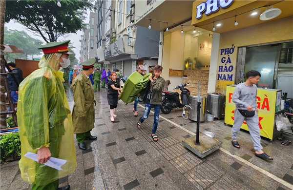 Cán bộ phường Hà Nội đội mưa thực hiện 'chiến dịch' giành lại vỉa hè cho người đi bộ