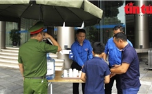 Thanh niên TTXVN hỗ trợ thông tin và nước uống cho người dân đến viếng Tổng Bí thư 