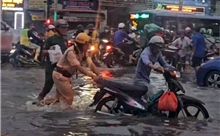 TP Hồ Chí Minh: Ấm lòng hình ảnh CSGT hỗ trợ người dân qua điểm ngập